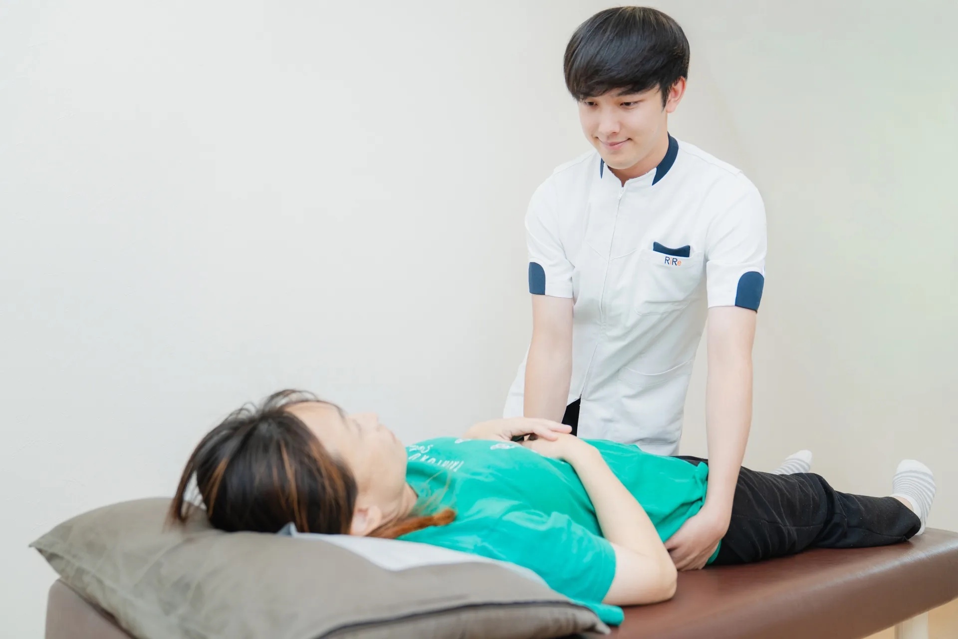 腰と骨盤周辺の動きを無理のない範囲で確認する施術風景
