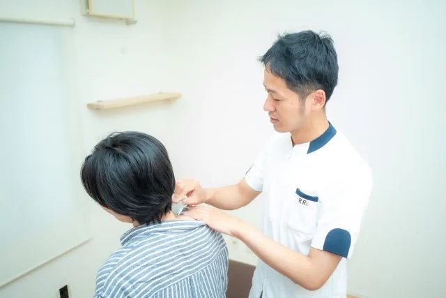 肩甲骨まわりに専用器具を用いる筋膜リリースの施術風景