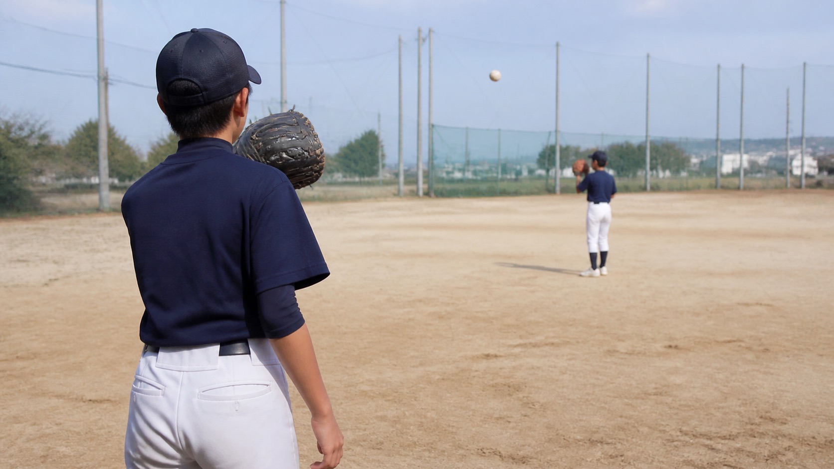 野球肘の確認後に短い距離から投球を再開する後ろ姿のイメージ